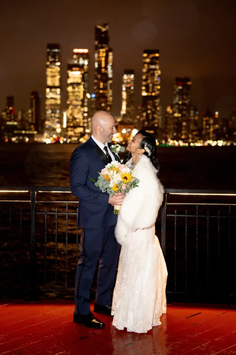 Wedding couple posing with a city skyline behind them