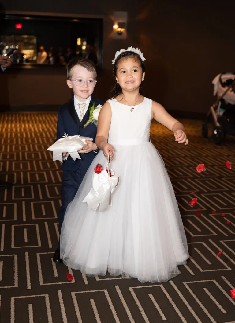 Two young wedding attendants walking together at the reception